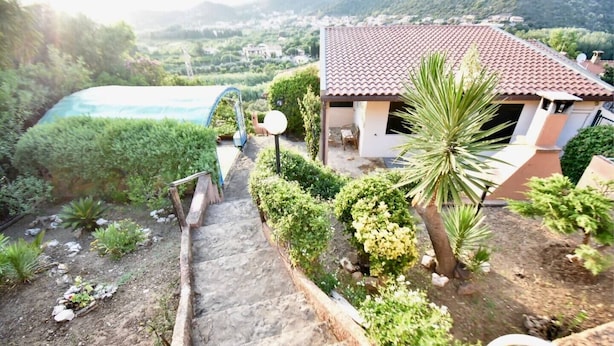 Il s’agit d’une propriété résidentielle dotée d’une piscine, d’un escalier menant à un patio couvert et offrant une vue sur le paysage environnant.