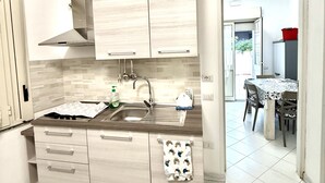 Una cocina moderna con alacenas de madera clara, una campana extractora de acero inoxidable y un salpicadero de azulejos.