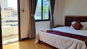 A hotel room with a large bed, a view of the city through a window, and a balcony. - Chan&Both guesthouse (Sihanoukville)