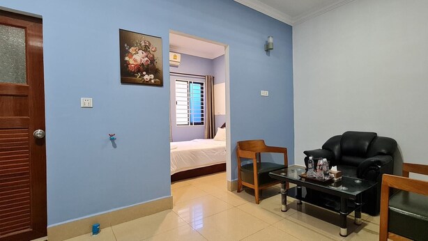A room with a bed, a table with chairs, and a wall-mounted air conditioner. - Chan&Both guesthouse (Sihanoukville)