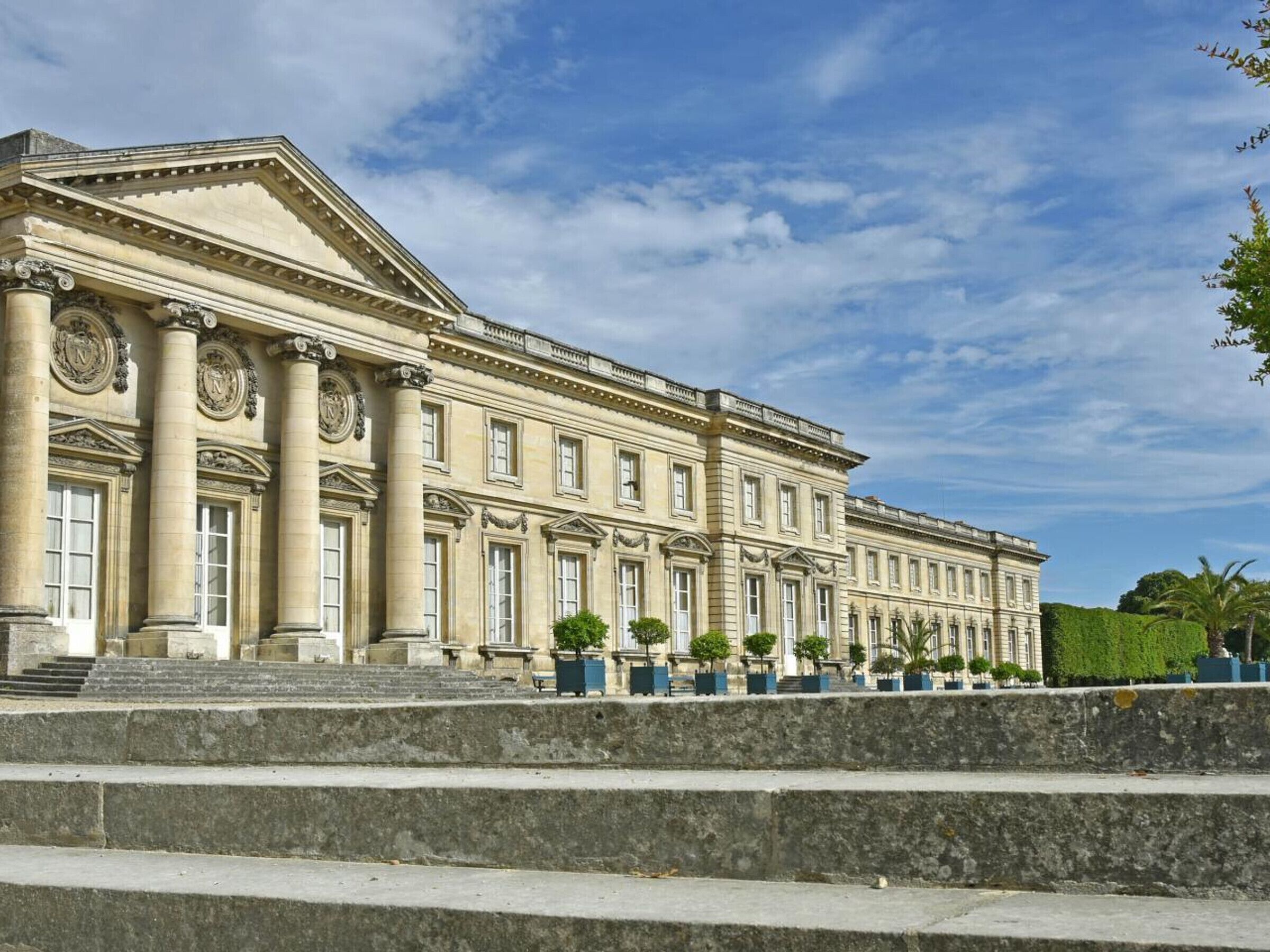 A large, classical building with symmetrical architecture, featuring columns and a grand entrance.