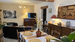 Un comedor acogedor con pared de piedra, televisor y un cuadro.