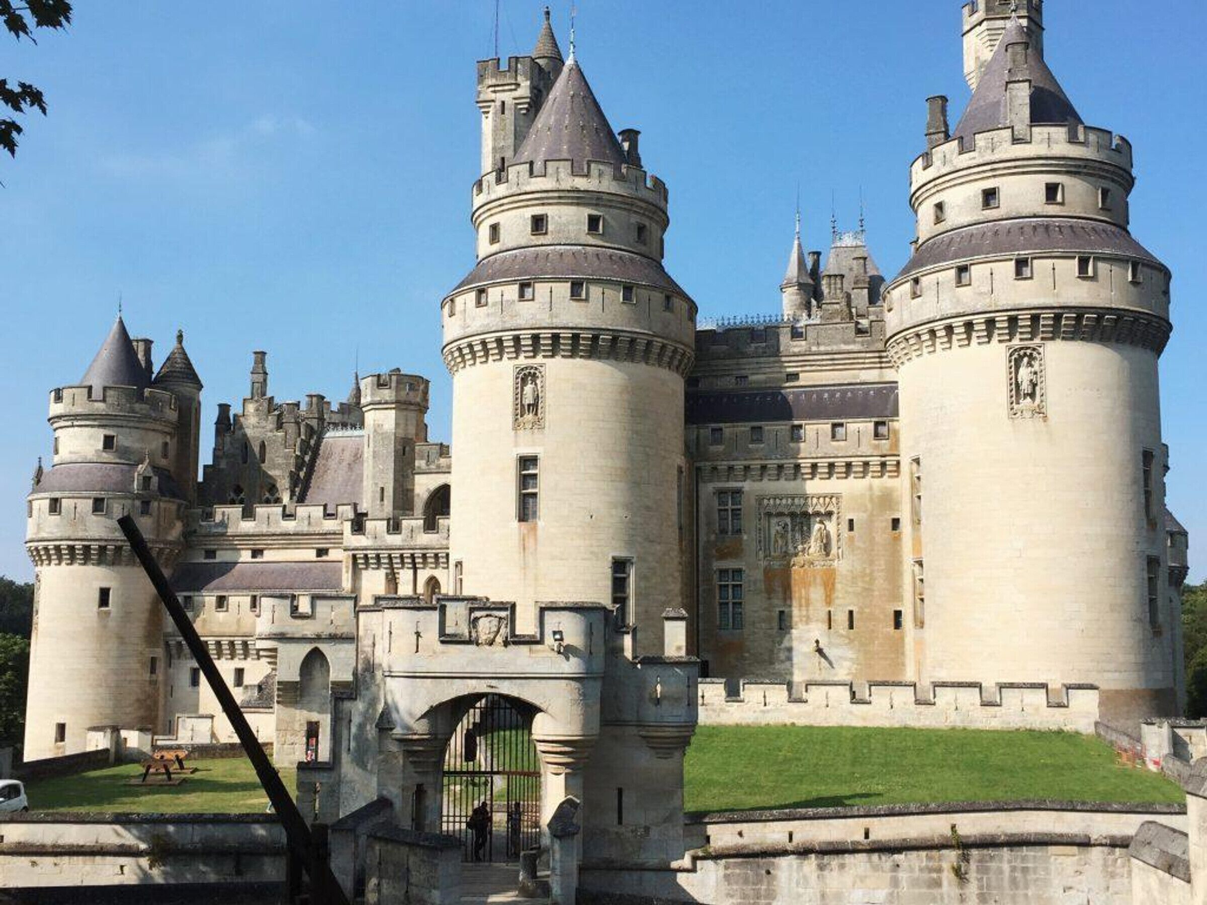 Um castelo grande e histórico com várias torres e um pátio central.