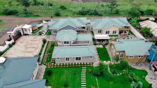 A residential area with multiple houses, each with a green roof and surrounded by well-maintained gardens. - LA'TONNA SAFARI HOTEL (Serengeti)