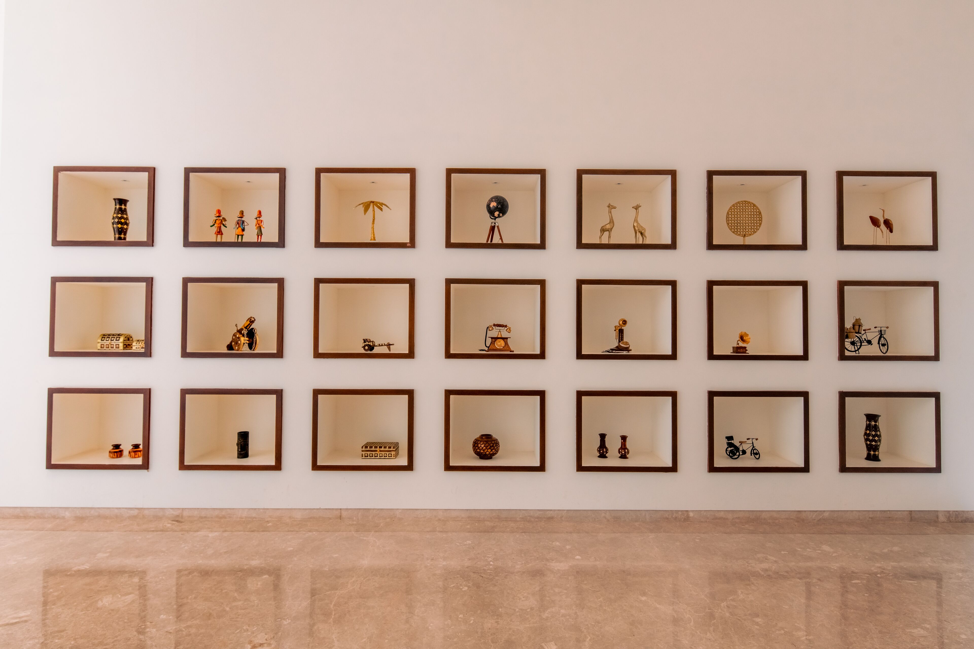 Un mur orné de 20 œuvres d’art encadrées, disposées selon un motif en grille.