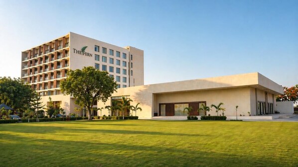 A hotel with a modern building and a well-maintained lawn. - The Fern Alwar (Malakhera)