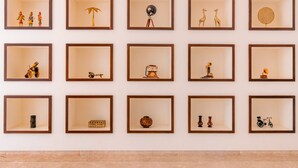 Un mur orné de 12 œuvres d’art encadrées, chacune représentant des objets et des scènes différents.