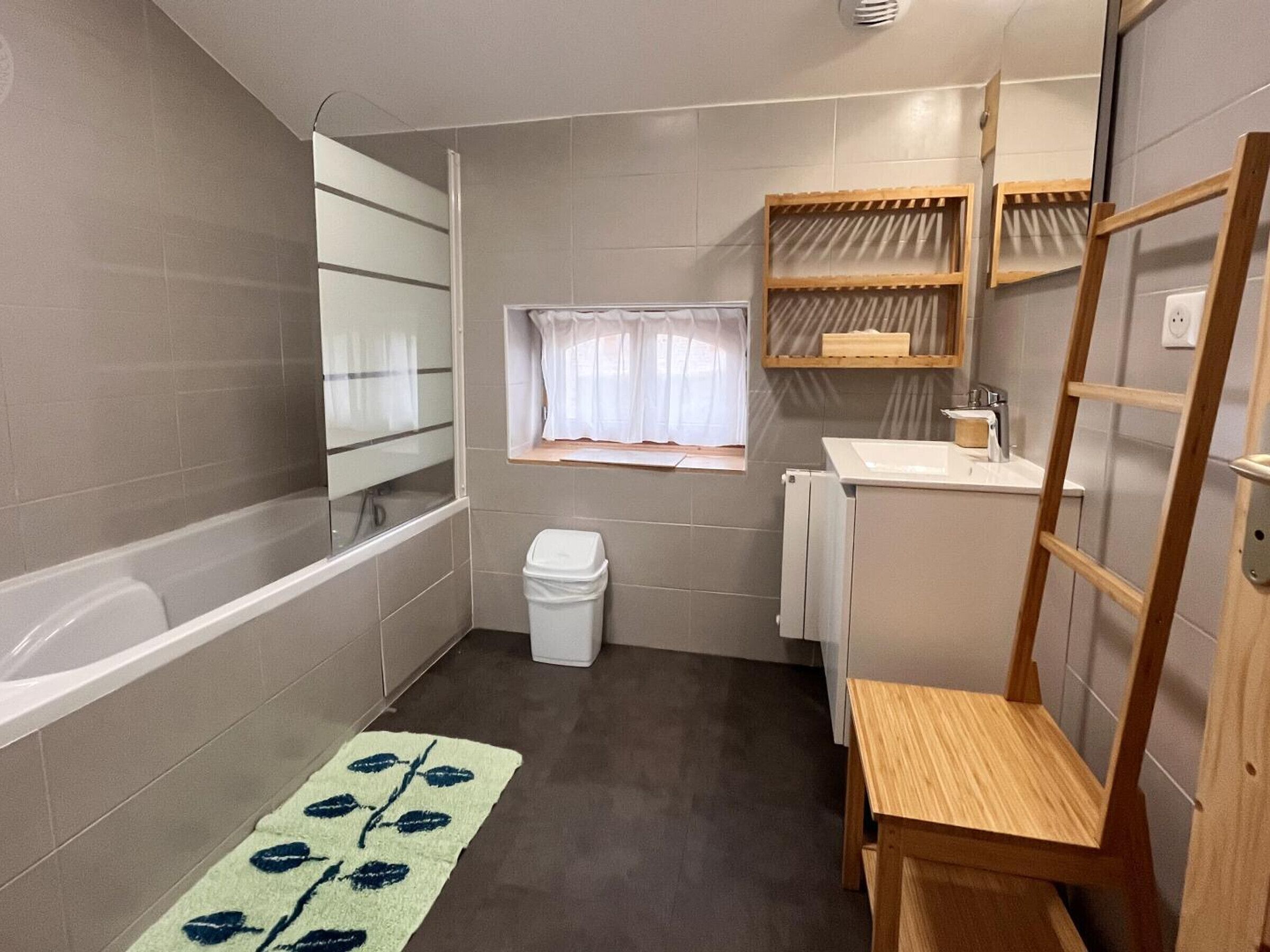 Une petite salle de bain comprenant une baignoire, des toilettes, un lavabo et une fenêtre.