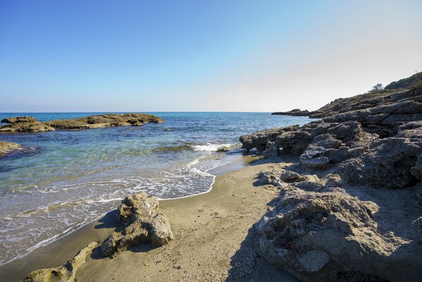 A rocky beach with clear water and a distant view of the sea. - Charming 2-Bedroom Apartment 100m from the Beach Terrace Fiber WiFi  (Linguizzetta)