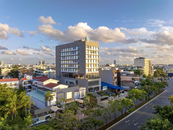 A modern building with a prominent sign, surrounded by other buildings and greenery. - Tru by Hilton Can Tho Cai Khe (Can Tho)