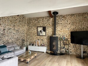 Smart-tv, eldstad, ett bordtennisbord och datorskärmar