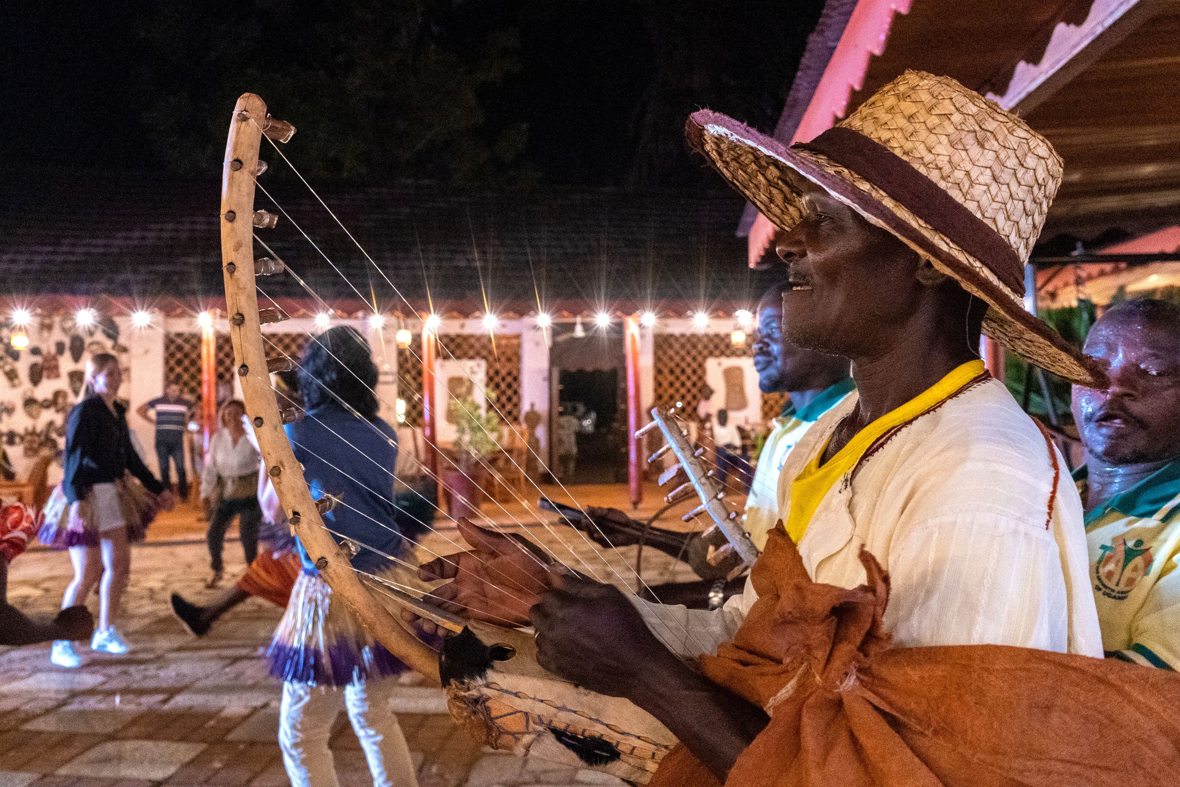Una persona tocando un instrumento de cuerda al aire libre de noche.