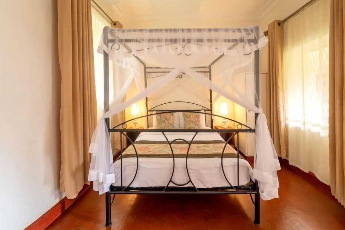 A bunk bed with a canopy, positioned in a hallway with curtains and a patterned rug.