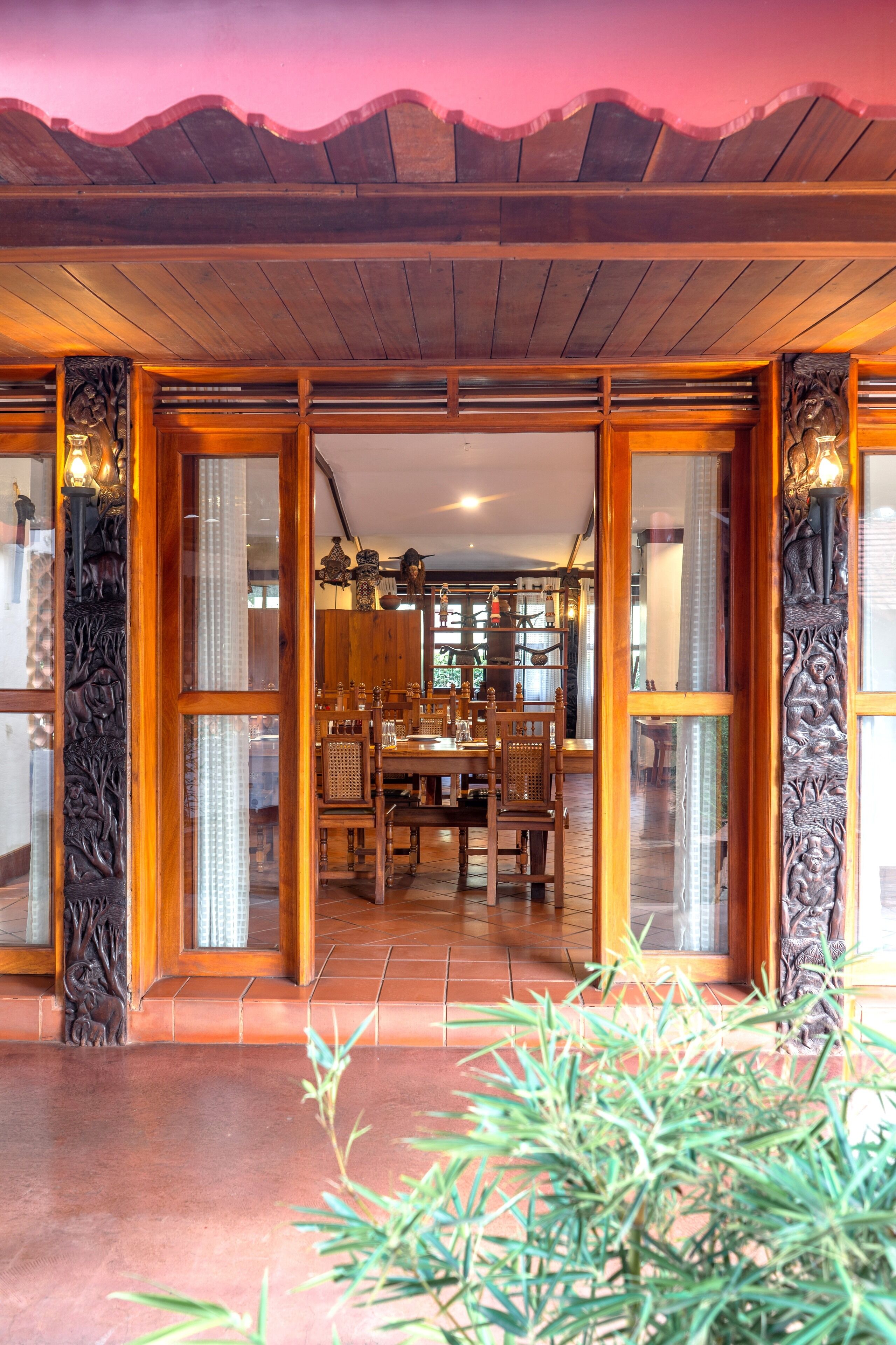 A wooden dining area with a tiled floor, a central table, and chairs.