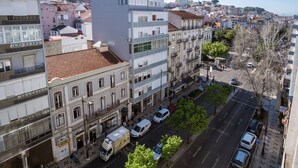 A multi-story building with a mix of residential and commercial spaces, including a visible storefront. - Studio 59 Lisboa (Lisbon)