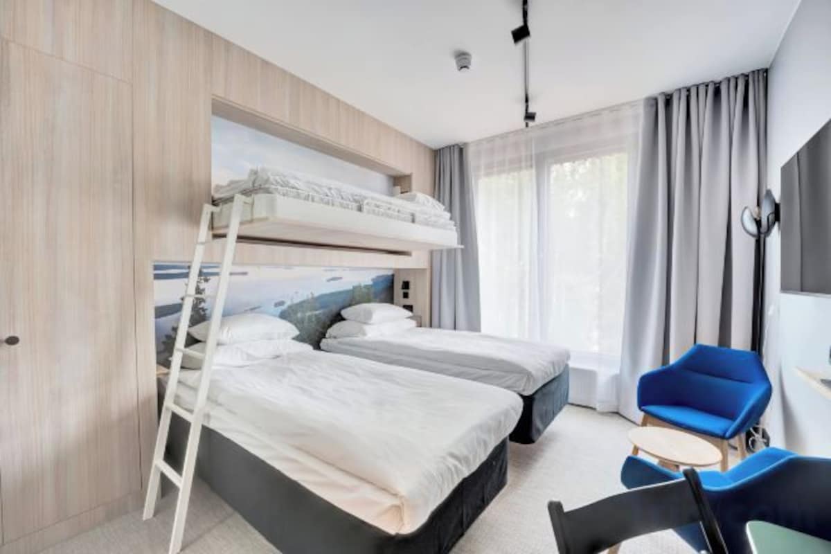 Une chambre d’hôtel avec des lits superposés, un bureau et une chaise.