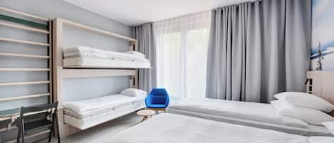 Ett modernt hotellrum med våningssängar, ett skrivbord och en stol.