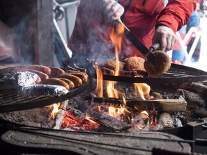 A grill with sausages being cooked over an open flame. - Break Sokos Hotel Koli Kylä (Lieksa)