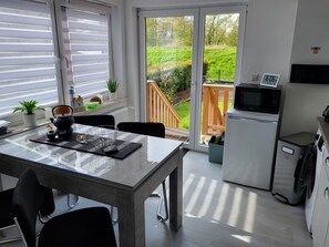 Enjoy meals in the kitchen with a view of the lush garden through the glass door.
