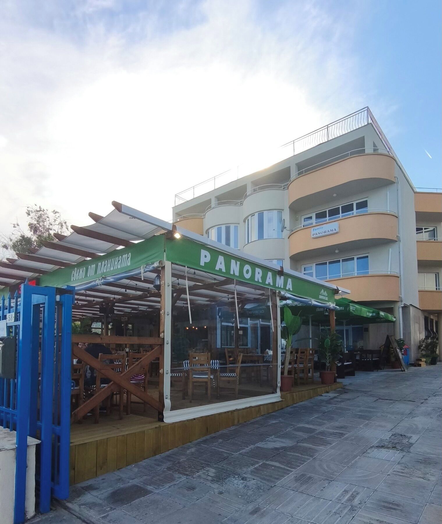 Ein Restaurant namens 'PANORAMA' mit Außenbereich und überdachtem Sitzbereich.
