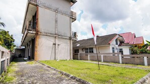 A two-story building with a flat roof and a balcony. - Hotel O Oklahoma Homestay Syariah (Pekanbaru)
