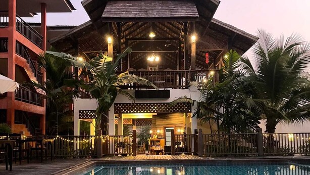A hotel with a swimming pool, a covered outdoor area, and a multi-story building with balconies. - Rainforest Huahin Village Hotel (Hua Hin)