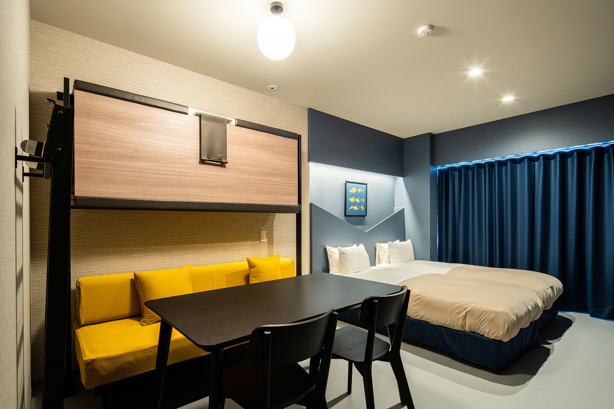 A hotel room with a bed, a sofa, a table, and a chair.