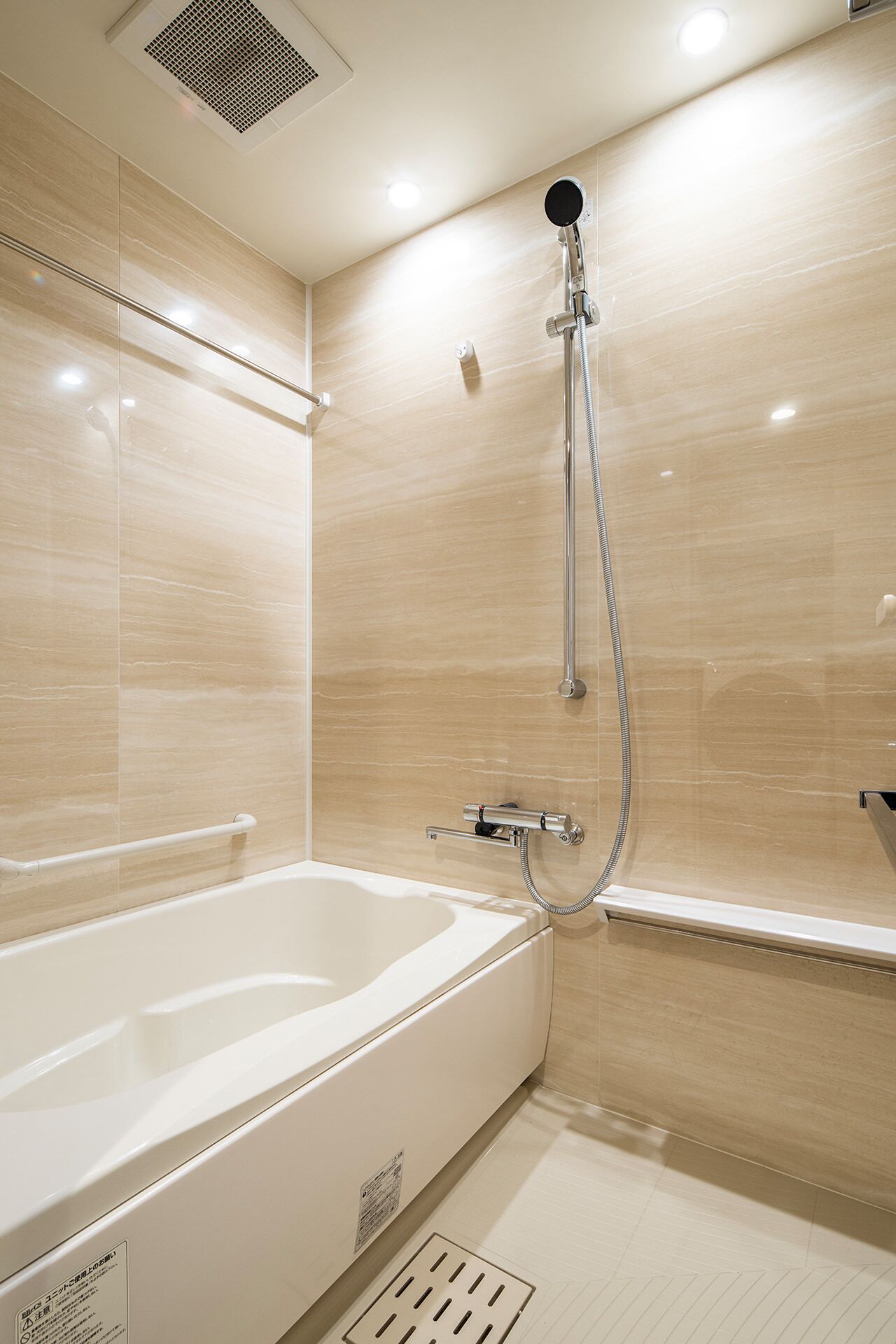 Un baño moderno con bañera, ducha y un respiradero en el techo.