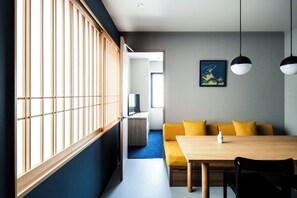 A modern interior with a dining area, a sofa, and a television. - Section L Tsukiji (Tokyo)