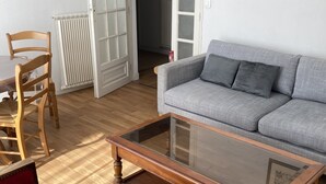Un salon avec une table basse en bois, un canapé gris et une chaise en bois.
