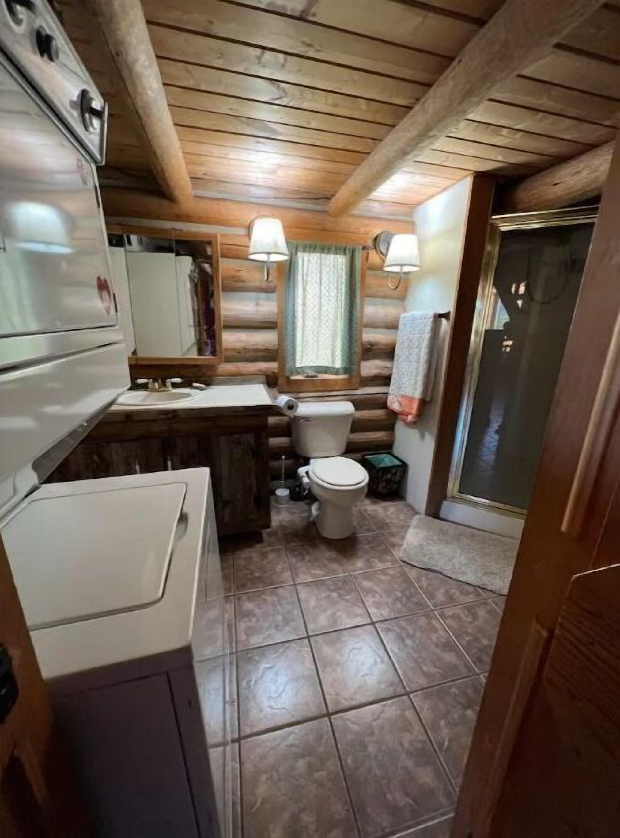 A compact bathroom with a toilet, sink, and a small cabinet.