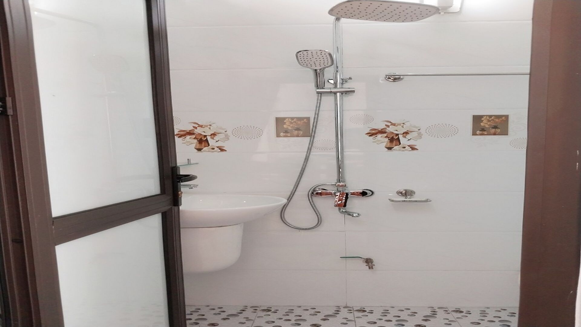 Une salle de bain avec douche, toilettes et lavabo.