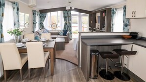 Cozinha moderna com área de jantar, banquetas e vista para o exterior.