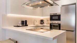 A modern kitchen with a central island, stainless steel appliances, and a sleek design.