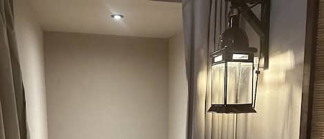 A compact bathroom with a toilet, a towel, a small sink, and a wall-mounted light fixture.