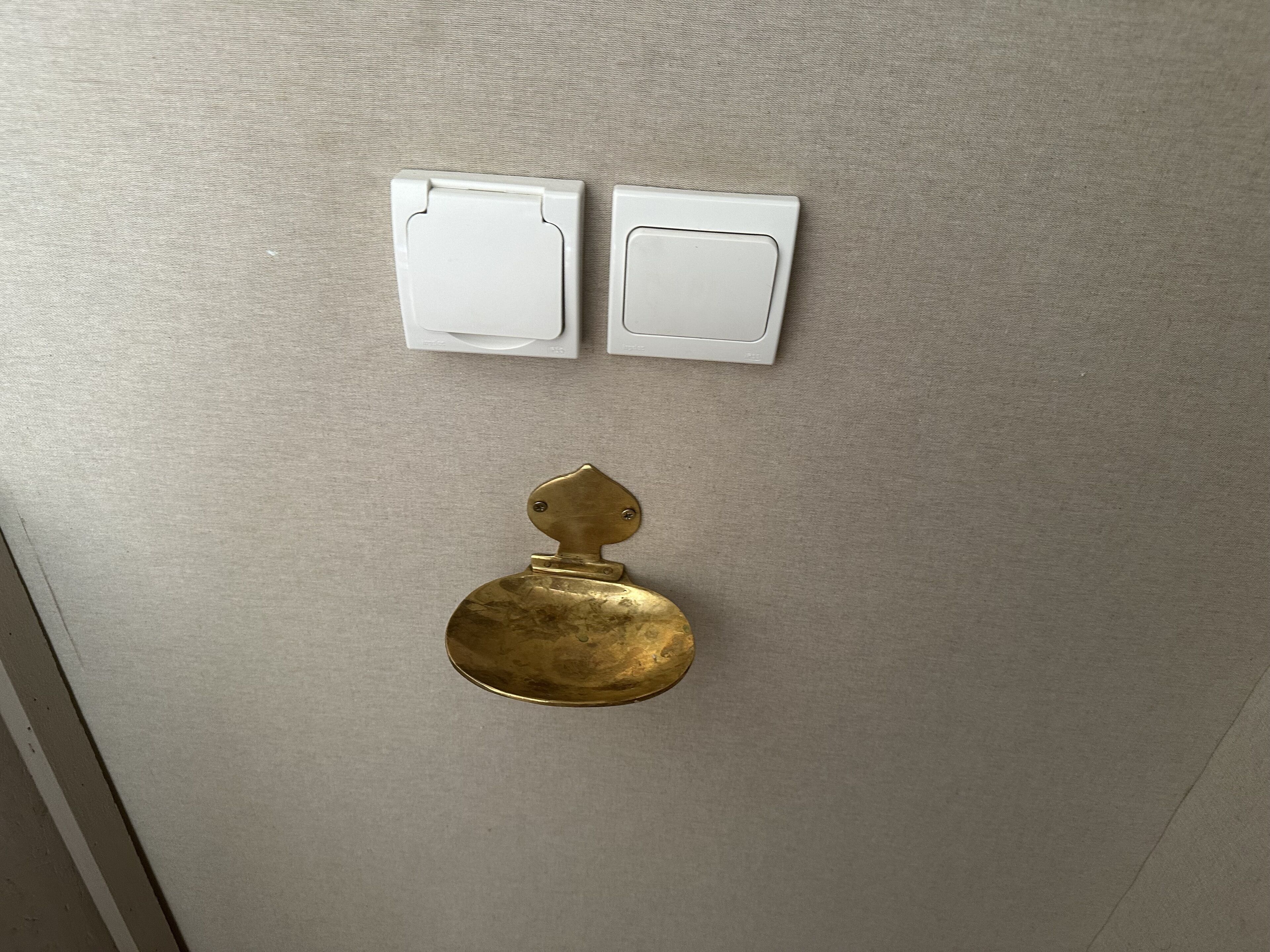 A door with a brass handle and two white switches above it.