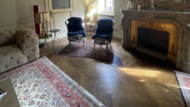 A room with a fireplace, two armchairs, a sofa, and a large mirror. - Charming apartment in Piazza Grande Modena (Modena)