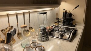 A kitchen with a gas stove, coffee maker, and various utensils. - Charming apartment in Piazza Grande Modena (Modena)