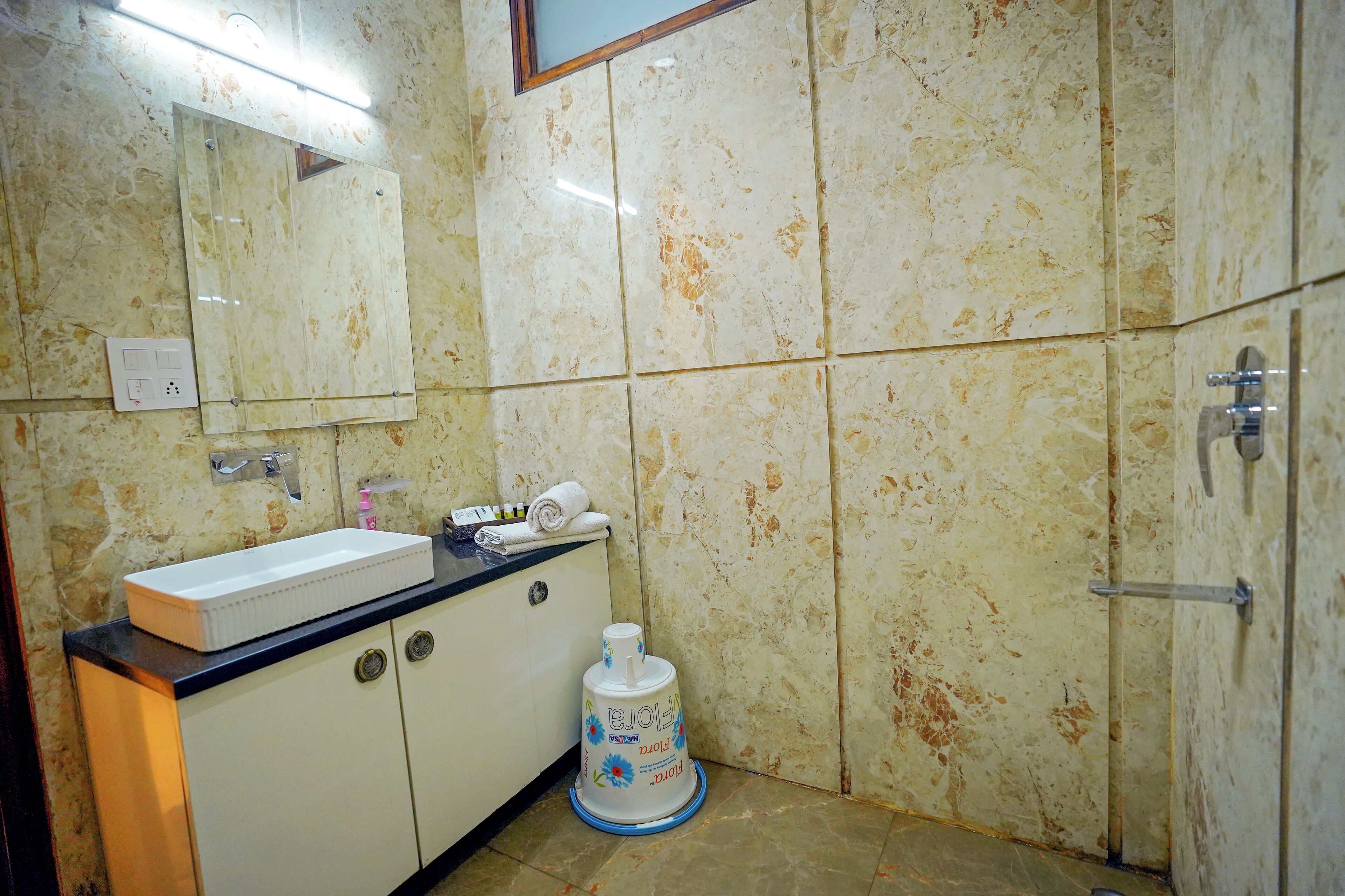 Un baño con lavamanos, espejo y secador de manos.