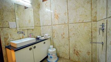 Un baño con lavamanos, espejo y secador de manos.