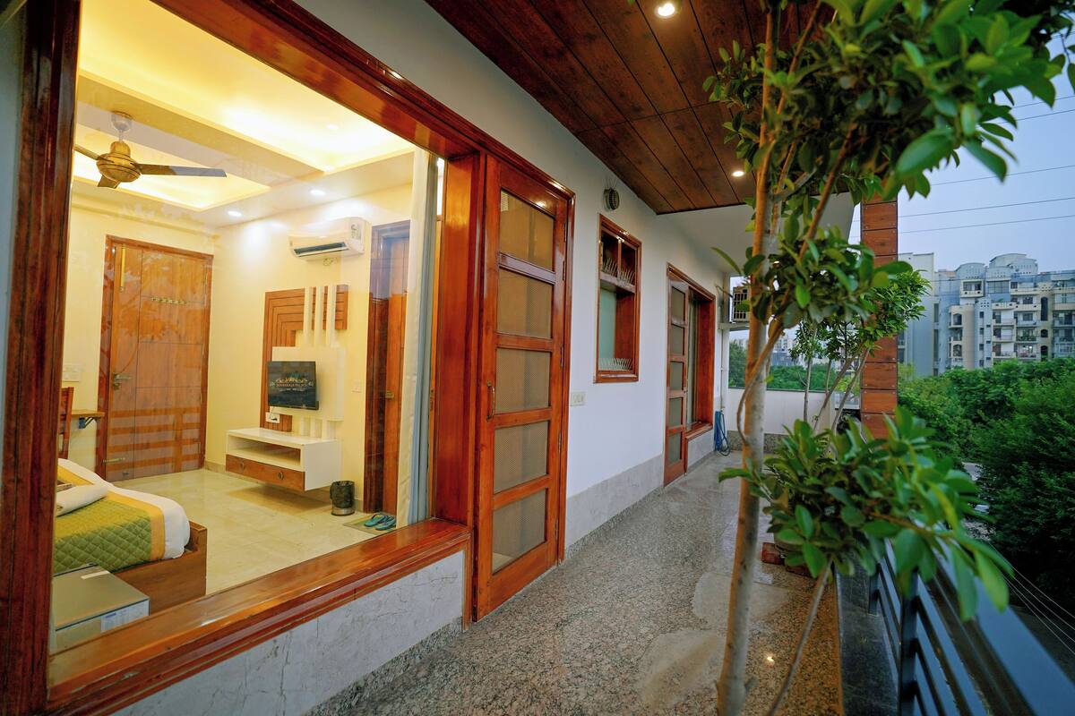 A hotel room with a large window, wooden door, and a ceiling fan.