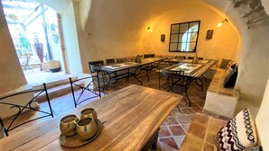 A spacious dining area with a long wooden table, multiple chairs, and a central island with a small table and stools. - Gîte 4* for 6p, 3ch, 100m2, HEATED SWIMMING POOL, PATIO (Vallon pont d'arc)