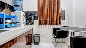 A compact kitchen with a water dispenser, a blue dish rack, and a marble backsplash. - Collection O 90253 DHelomi (Depok)