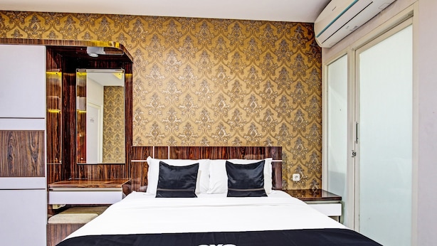 A hotel room with a bed, a wardrobe, and a mirror. - Collection O 90253 DHelomi (Depok)