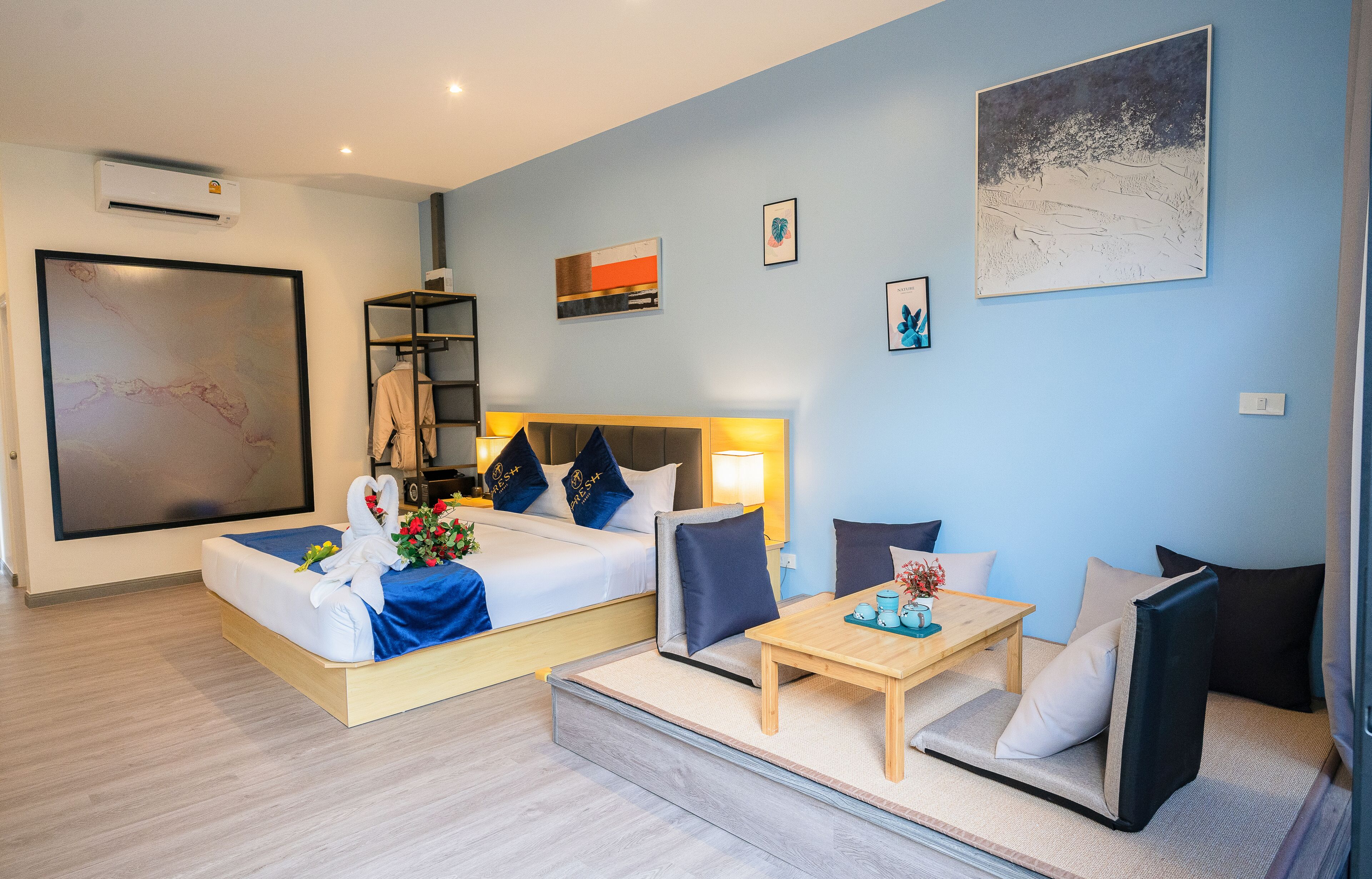 A hotel room with a bed, a sofa, a small table, and a TV.