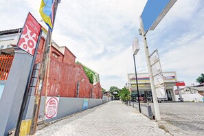 Straatbeeld met een rood gebouw, een benzinestation en een bord voor Hotel Oman.