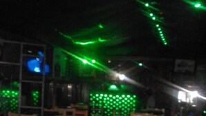 A bar area with wooden chairs and a long black counter. - Hotel Bison (Nakuru)