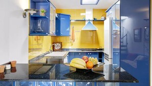 A kitchen with blue cabinets, a sink, and a fruit bowl on the counter. - Puerto del Carmen Vacation Apartment (Puerto del Carmen)