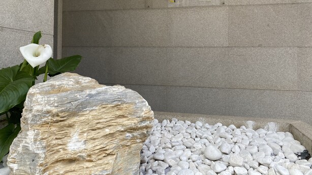 Un muro de piedra con un cartel que dice "EL RINCONCITO de dpCristal" y una señal de estacionamiento.