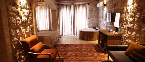 A room with a bed, a sofa, a small table, and a TV.